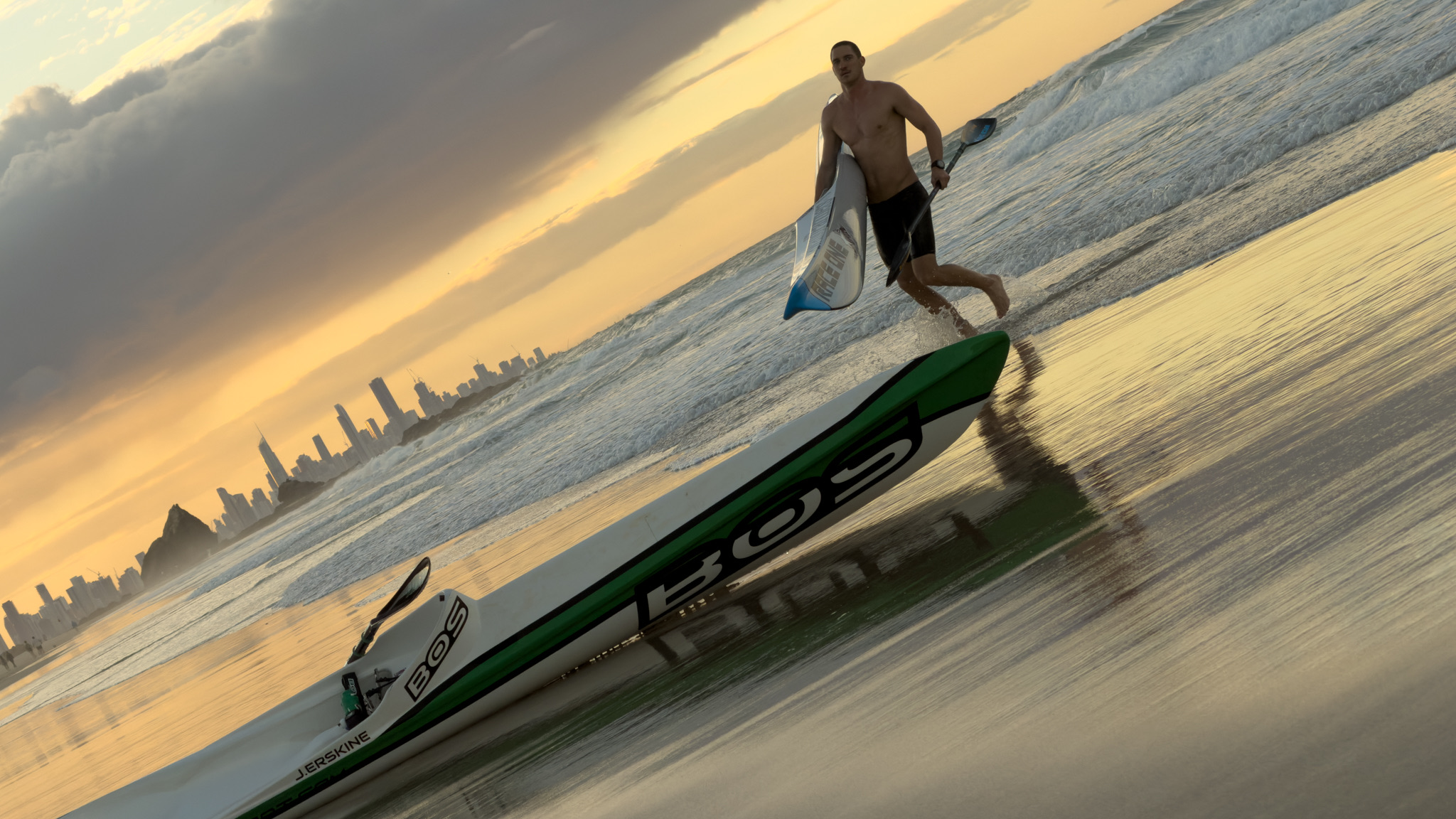 A paddler running his surf-ski into the shorebreak at Currumbin at first light.